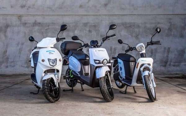 Trois différents modèles de scooter stationné