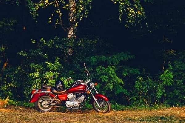 Moto rouge garée dans la forêt